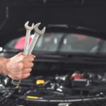 mechanic-holding-pair-of-wrenches-at-the-repair-garage